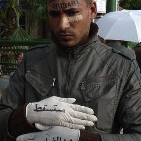Face painted: 'Get out Mubarak' and latex gloves reading: 'You will fall by the hands of the youth'
