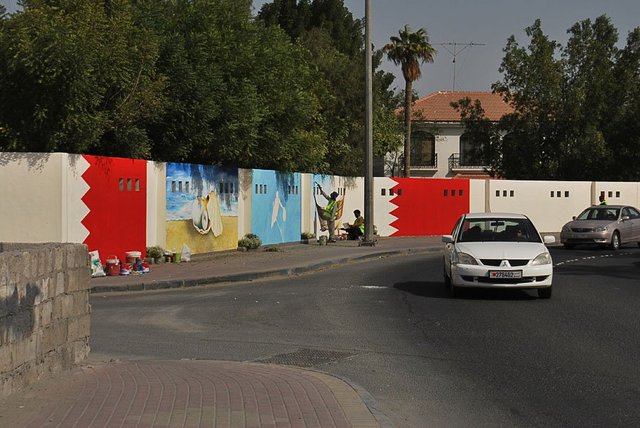 Near the &lsquo;Bulls head&rsquo; roundabout in Sehla, Bahrain, a &lsquo;beautification&rsquo; team paint walls with images of pearl divers, dhows and oysters.  Photograph by Amal Khalaf.